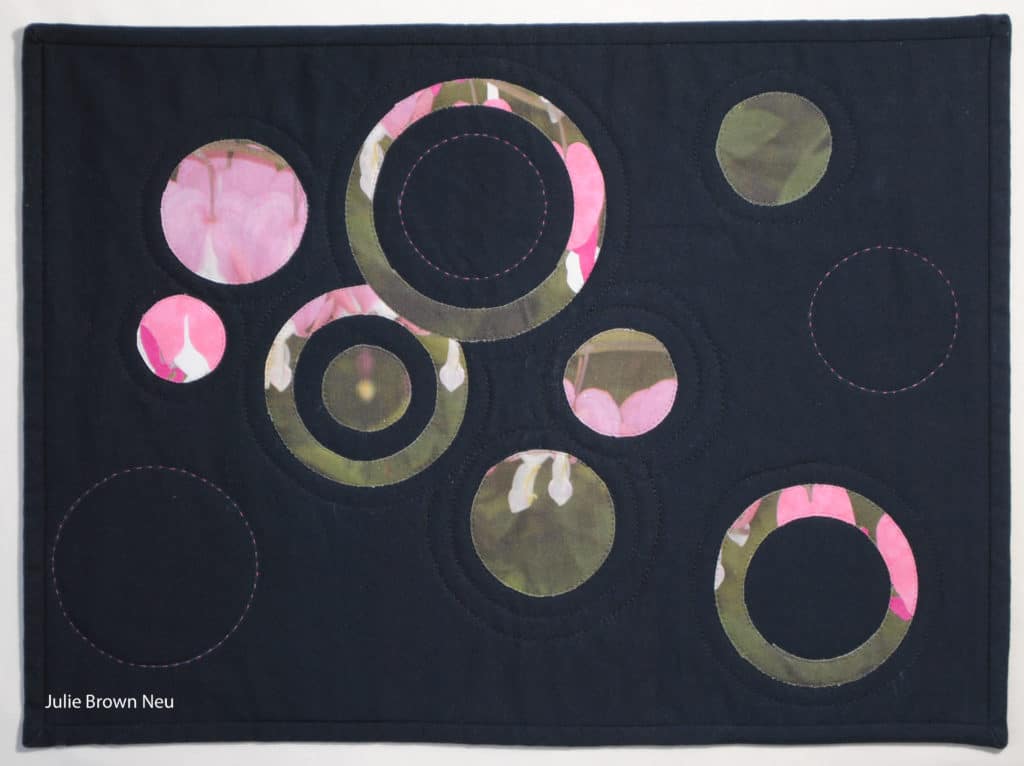 Julie Neu, art quilt of pink and green circles from bleeding hearts plant photo on black background