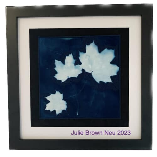 black framed cyanotype of three white maple leaves on a stem on blue background