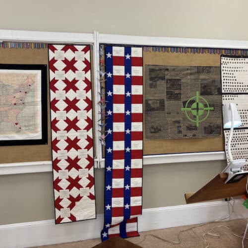 quilts hanging on bulletin board behind lectern